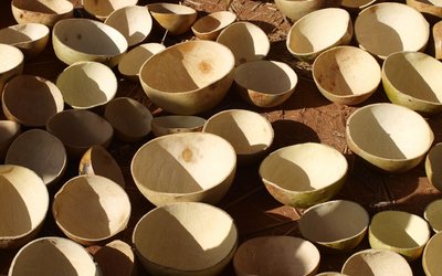 numerous crafted beige bowls made of natural materials standing on the brown ground